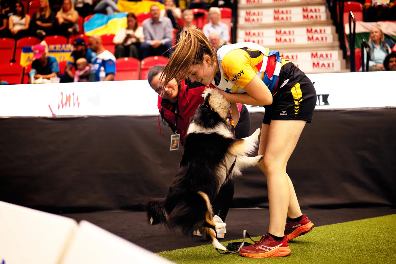 Andrea Prezzi gebogen over haar hond na een agility-run op een internationaal kampioenschap